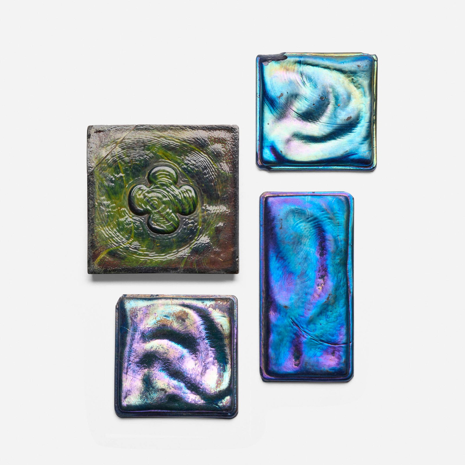 Tiffany Studios, Collection of four tiles: Tiffany Studios Collection of four tiles USA, c. 1910 Favrile glass largest: 3 h x 3 w x 0.25 d in (8 x 8 x 1 cm) smallest: 2.375 h x 2.375 w x 0.25 d in (6 x 6 x 1 cm) Provenance: Collection of Mark