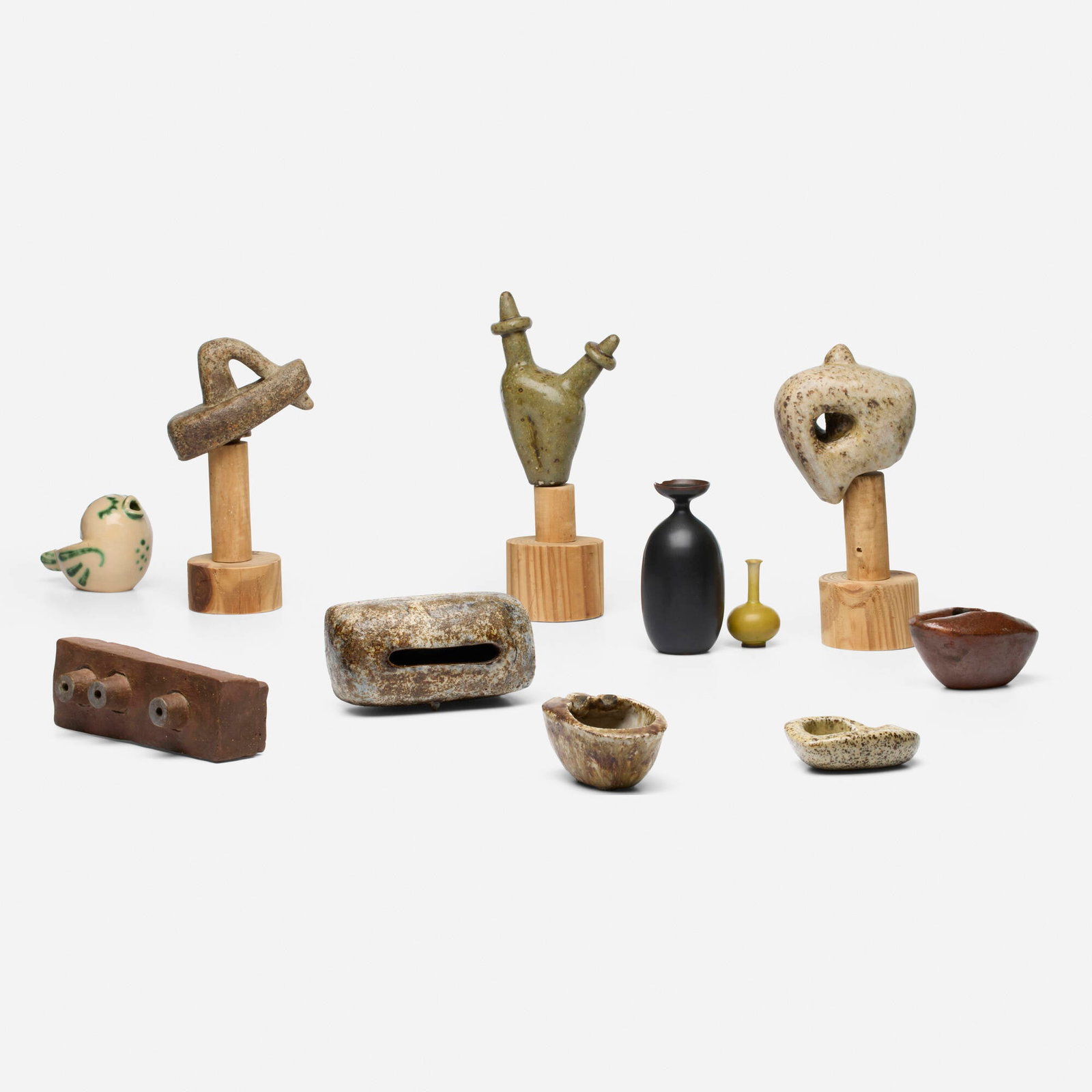 Leza McVey, Collection of nine works: Leza McVey Collection of nine works USA, c. 1955 glazed stoneware, wood tallest: 9.75 h x 4 w x 2.75 d in (25 x 10 x 7 cm) shortest: 1 h x 3.5 w x 2.5 d in (3 x 9 x 6 cm) Collection is comprised of