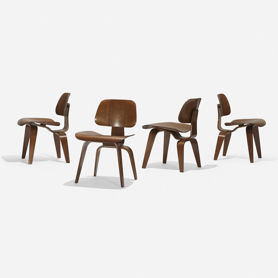 Charles and Ray Eames DCWs, set of four: Charles and Ray Eames DCWs, set of four Herman Miller USA, 1945 walnut plywood, rubber 19.5 w x 21 d x 29 h inches Signed with applied foil manufacturer’s label to underside of three examples: [Char