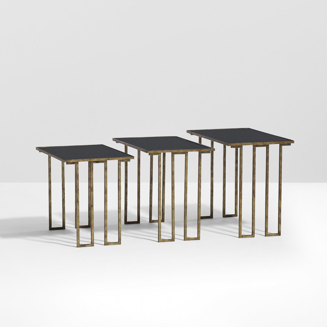 Jean Royere Creneaux nesting tables, set of three: Jean Royere Creneaux nesting tables, set of three France, 1954 gold-patinated iron, black glass 19.75 w x 11.75 d x 15.75 h inches Literature: Jean Royere, Galerie Jacques Lacoste and Galerie Patrick