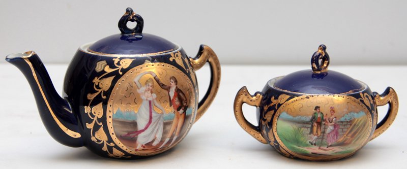 BEAUTIFUL HAND PAINTED ROYAL VIENA STYLE TEAPOT AND: Beautiful hand painted royal viena style mini teapot and sugar set. Fabulous cobalt blue with gilt scrolls and a scene depicting a couple on each. witha romantic scene. the teapot measures approx 3" h