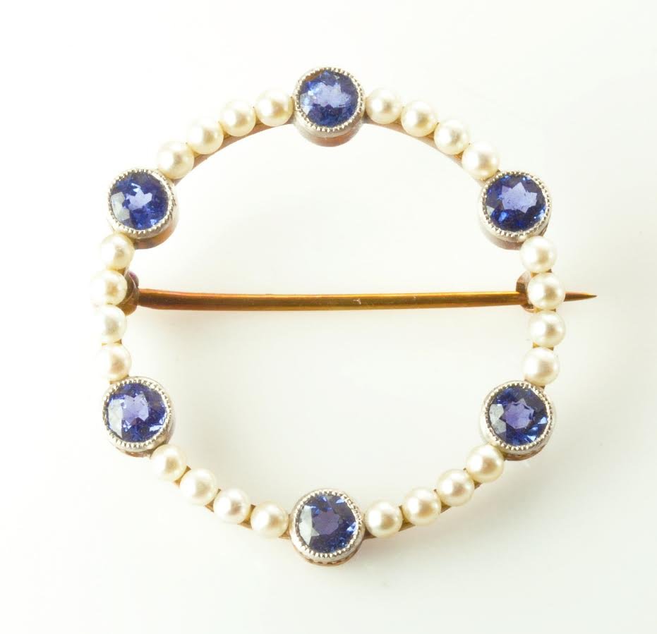 This is a Victorian natural pearl and Montana sapphire: This is a Victorian natural pearl and Montana sapphire brooch. The brooch features a sectional design studded with 6 round faceted natural sapphires that weigh approximately 1.00cts. They are fram