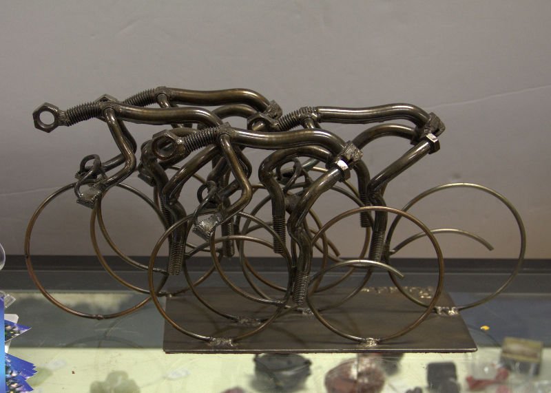 F. Russo Nuts and Bolts Sculpture: F. Russo vintage nuts and bolts sculpture of four cyclists. Measures 19 1/2" long x 7 1/2" wide x 9" high