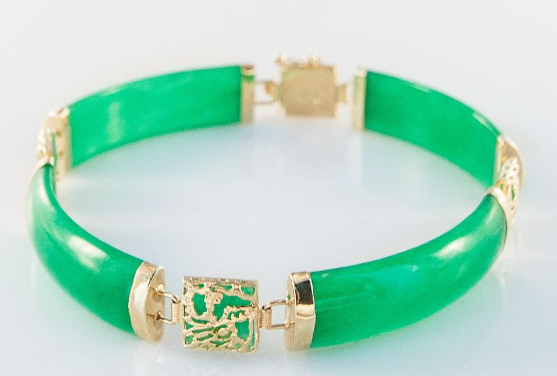 Contemporary Jadeite Jade Bracelet: Contemporary Jadeite Jade Bracelet featuring a semi ridged sectional cylindrical link jade design flanked with 14K yellow gold spacers measuring 7 inches in length and weighing 8.30dwt.