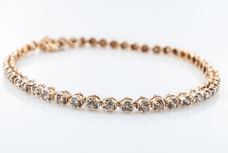 Contemporary Yellow Gold Diamond Tennis Bracelet: Contemporary Yellow Gold Diamond Tennis Bracelet 2.00Cts, featuring a sectional straight line design studded with 50 round brilliant cut diamonds weighing approx. 2.00cts combined and set into a handm