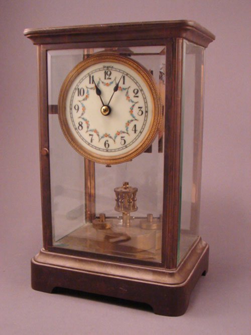 Kienzle Uranium 400 Day Crystal Regulator Clock.: Kienzle Uranium 400 Day Crystal Regulator Clock. Disc pendulum detached. Small chip to edge of beveled glass. 11"h x 7"w x 5 1/4"d.