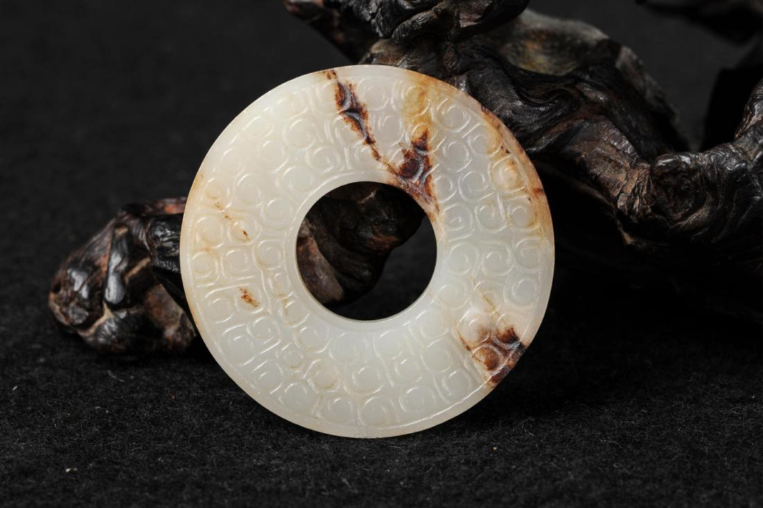 CHINESE WHITE JADE BI PENDANT: Ming dynasty or later. Outer diameter: 55 mm, inner diameter: 21 mm, thickness: 7 mm, weight 35.9 g