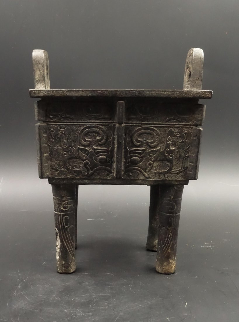 A CHINESE BRONZE BEAST MASK "DING" CENSER: Ming Dynasty. One leg has damage. Height: 23 cm.