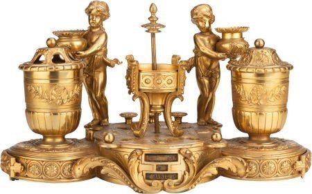A NAPOLEON III GILT BRONZE FIGURAL ENCRIER: A 19TH CENTURY NAPOLEON III GILT BRONZE TWO-LIGHT FIGURAL CALENDAR ENCRIER, 7" high x 13" diameter . Stamped : LEON & ROY, BREVETES S.G.D.G. Estimate $1.500-2.000
