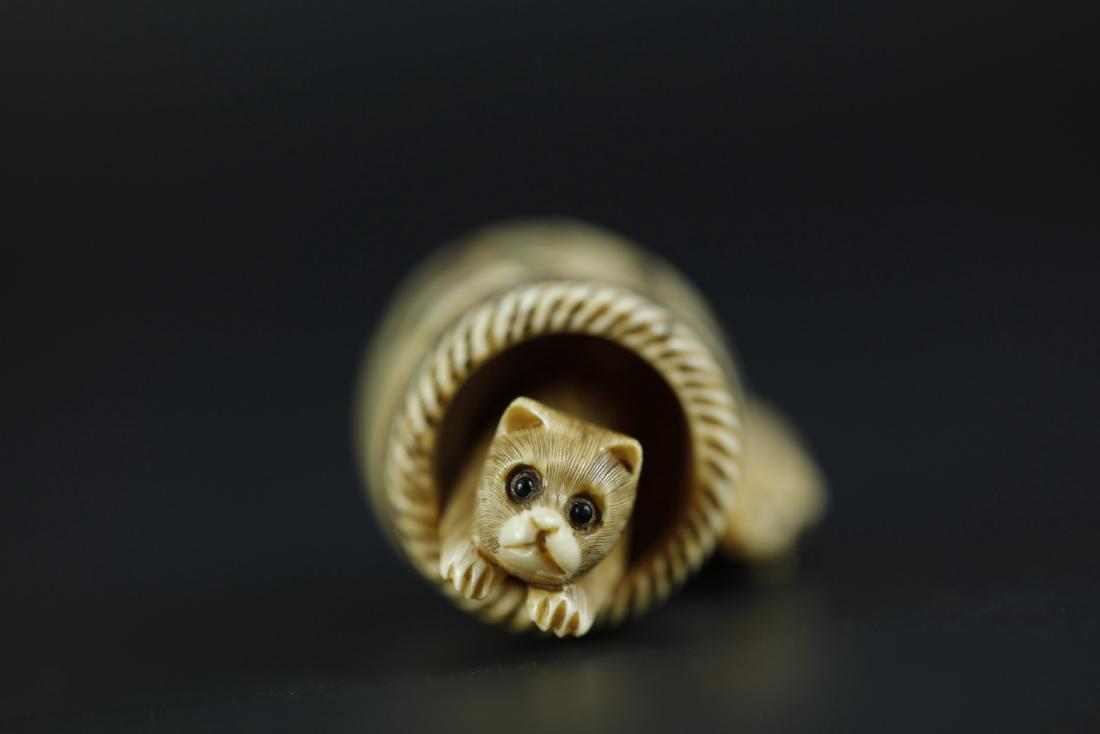 Japanese Netsuke carving of A cat in the barrel eith a: H: 1.5 W: 1.25 D: 1 inches