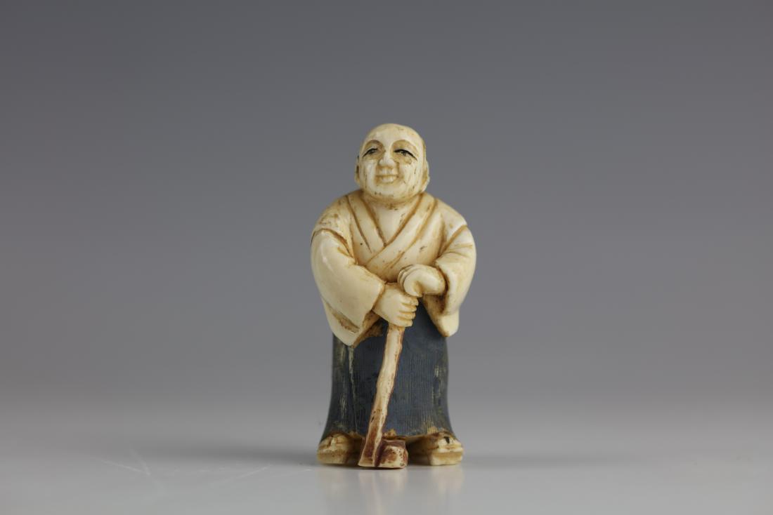 A Signed Carved Bone Netsuke of a Man with a Sword: H: 2 inches/5.1 cm