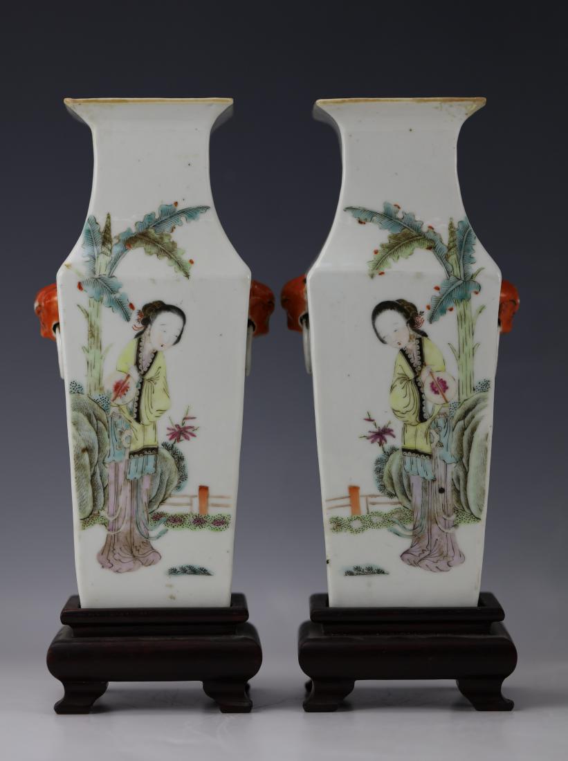 A pair of Square Famille Rose Storied Vase: A Pair of Square FIGURAL POEM Famille Rose Vases with Carved Wooden Stand. H: 8.8 in. (22.35 cm.)