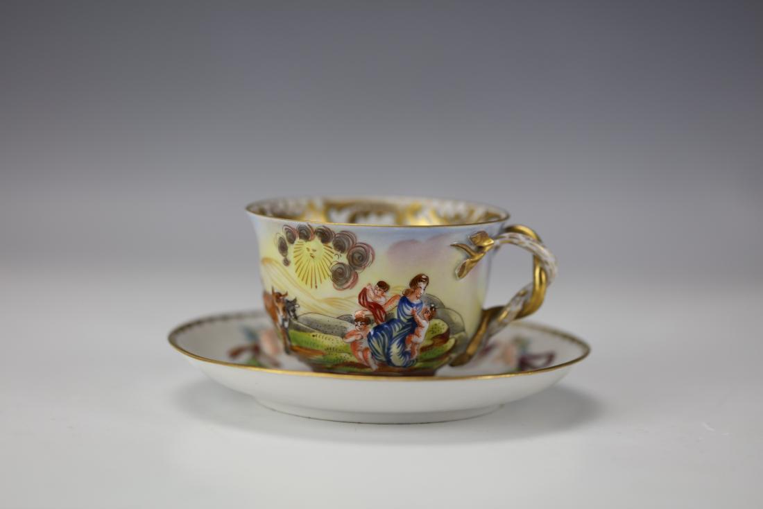 A Gilt "Cherub and Ribbon" Capodimonte Teacup and Sauce: A gilt "cherub and ribbon" capodimonte teacup and saucer set, and the date is 1850s-1870sCup D: 3 in. (7.62 cm.) Saucer D: 4.85 in. (12.32 cm.)