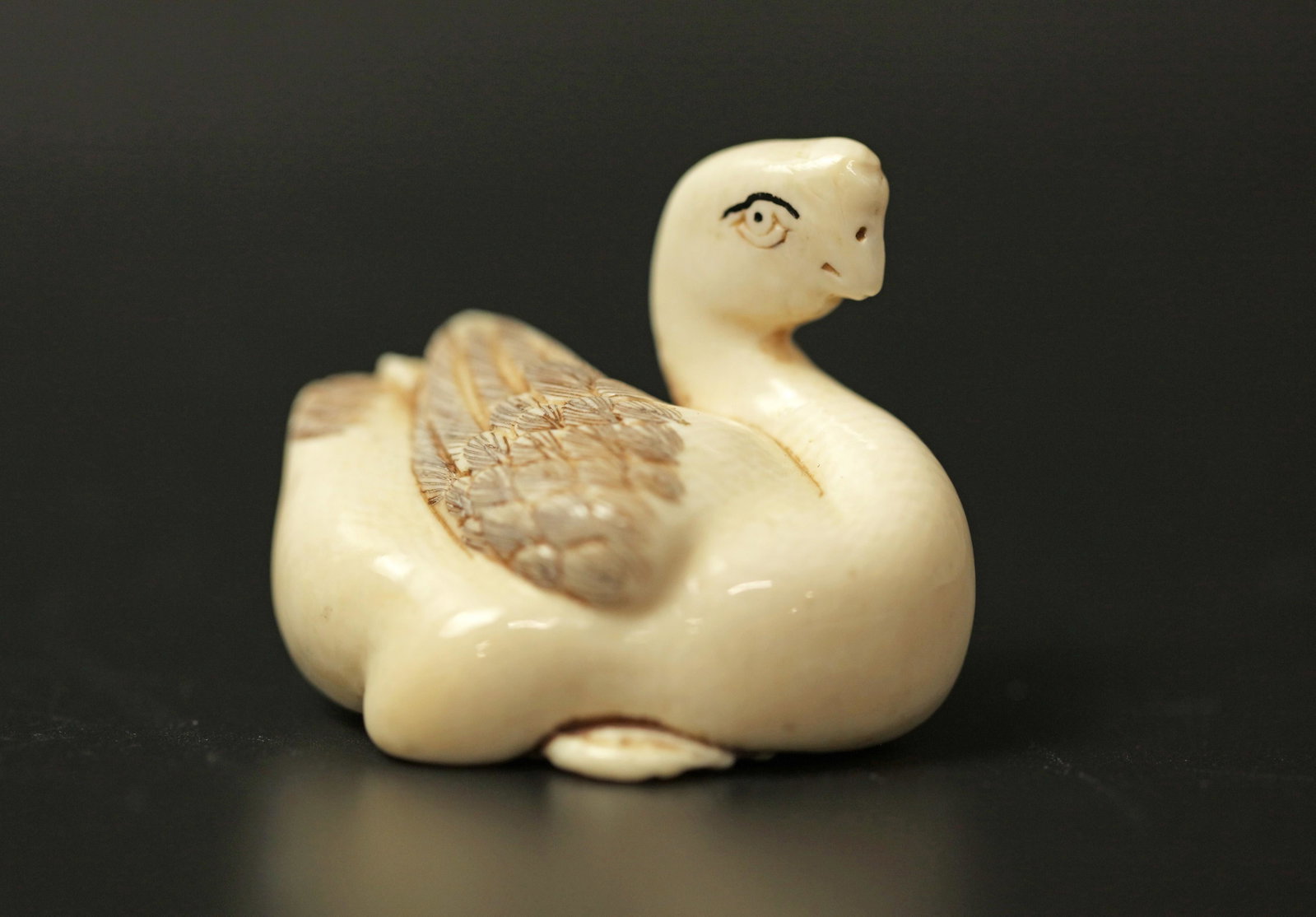 A Netsuke Miniature Carved Bone Sculpture of a Water: A Netsuke Miniature Carved Bone Sculpture of a Water Bird or Swan. H: 1.6 in. (4.06 cm) W: 2 in. (5.08 cm) D: 1.5 in. (3.81 cm)