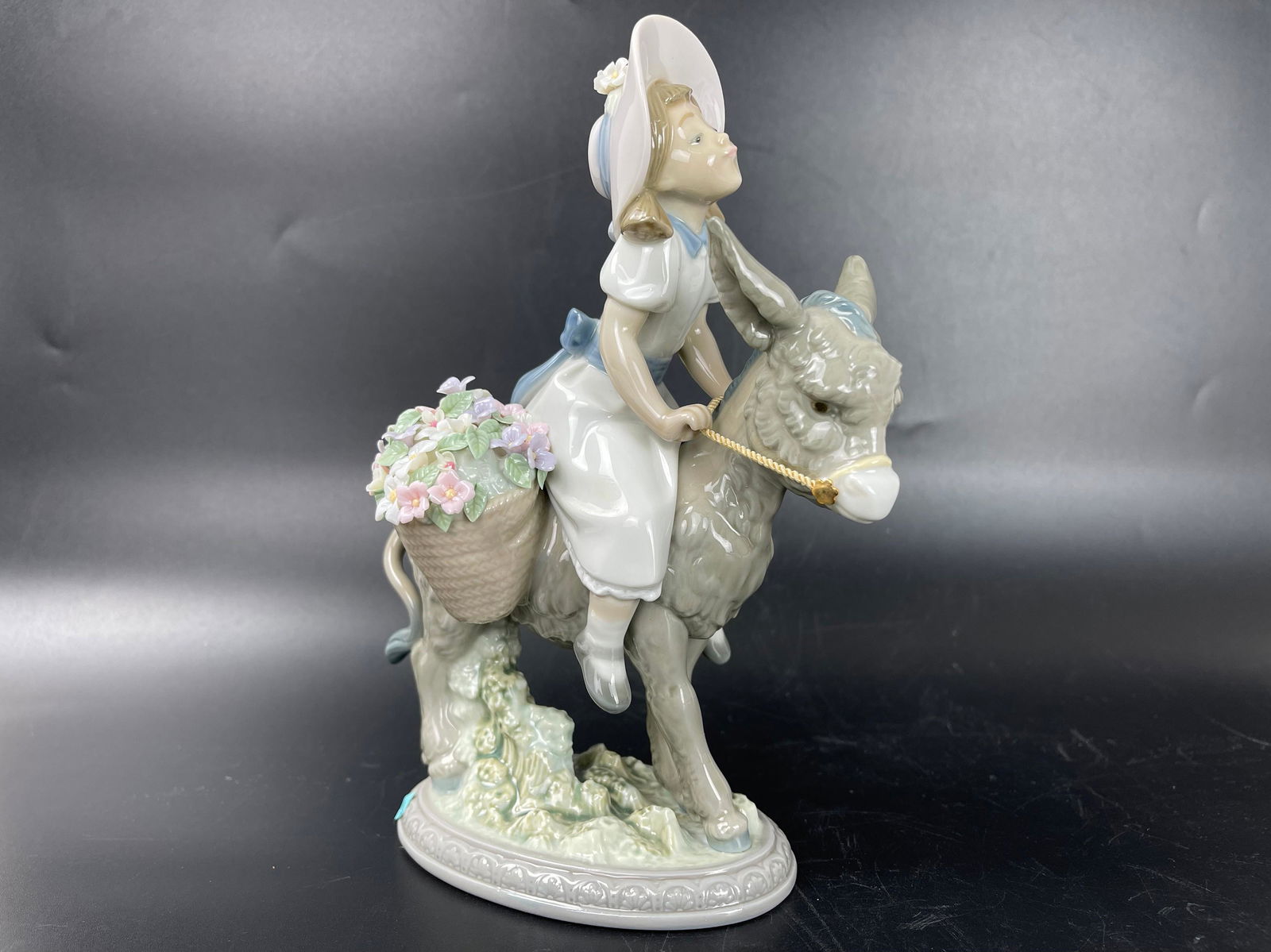Lladro Look at Me Porcelain Figurine: Lladro glossy porcelain sculpture of a little girl riding a donkey. H 8 in. W 3 in. D 4.5 in.