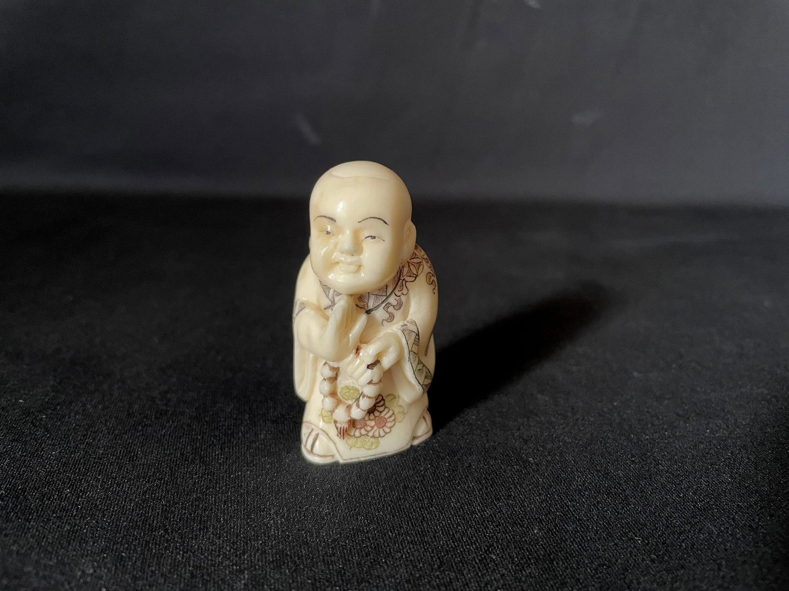 A Carved Cattle Bone Netsuke of Monk: A Carved Cattle Bone Netsuke of Monk. H: 2 in. W: 1 in. D: 0.75 in