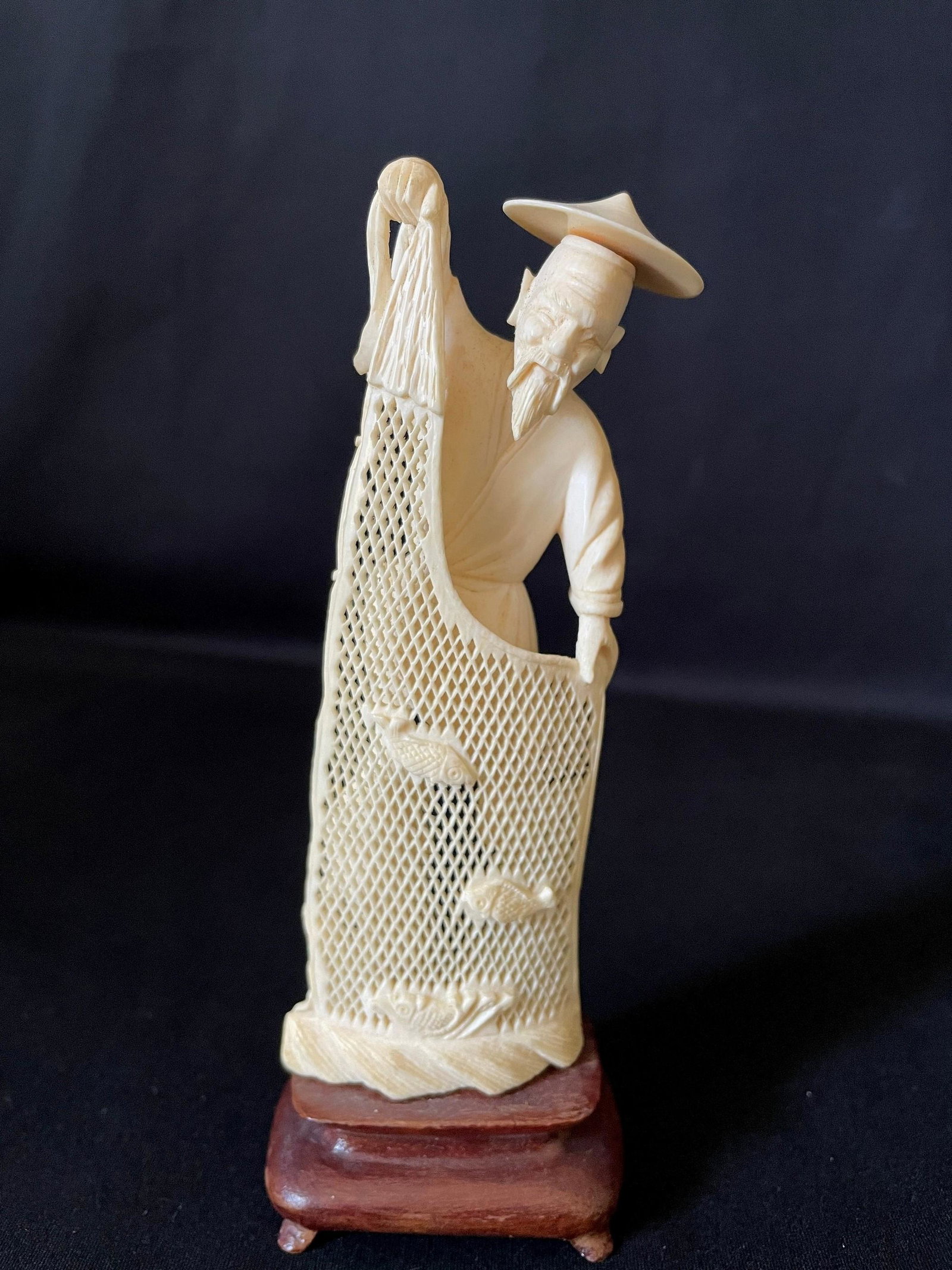 A Carved Cattle Bone Netsuke of Fisherman: A Carved Cattle Bone Netsuke of Fisherman. H: 5 in. W: 2 in. D: 1 in