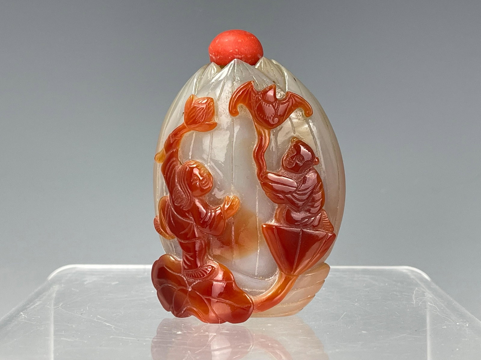 Agate Snuff Bottle: Agate Snuff Bottle, China, flattened lotus bud form with a flat oval foot, carved with petals ending in points at the mouth and decorated with two boys playing on a lotus plant, one releasing a bat, t