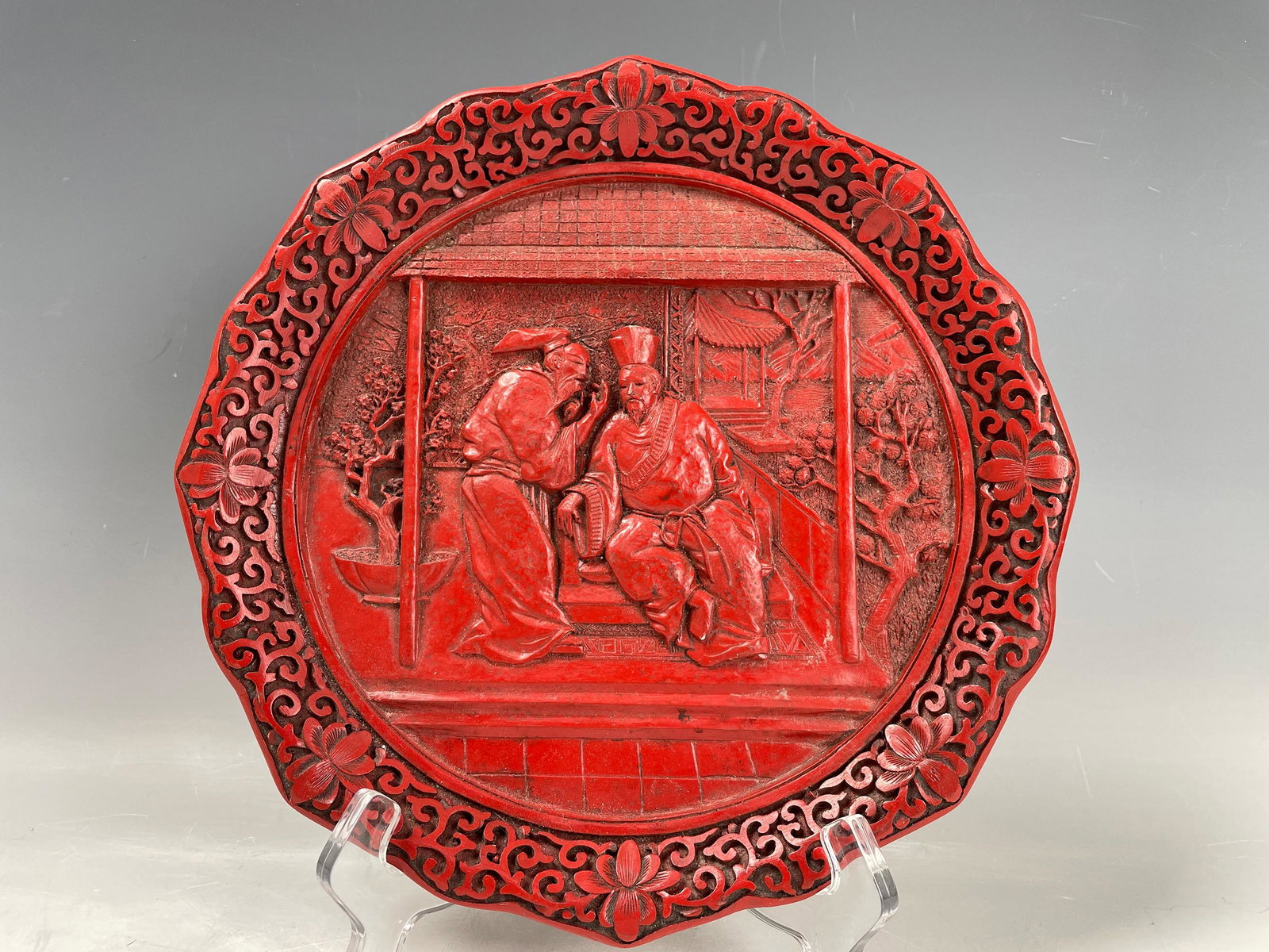 A Cinnabar Display Plate Figural Stories Lacquerware: A Cinnabar Display Plate Figural Stories Lacquerware, D 24 cm(9.5 in.),Preview from Apr. 17th to 21st from 1:00 PM TO 5:00 PM Eastern Time, Location: 15229 Display Court, Rockville MD 20850.