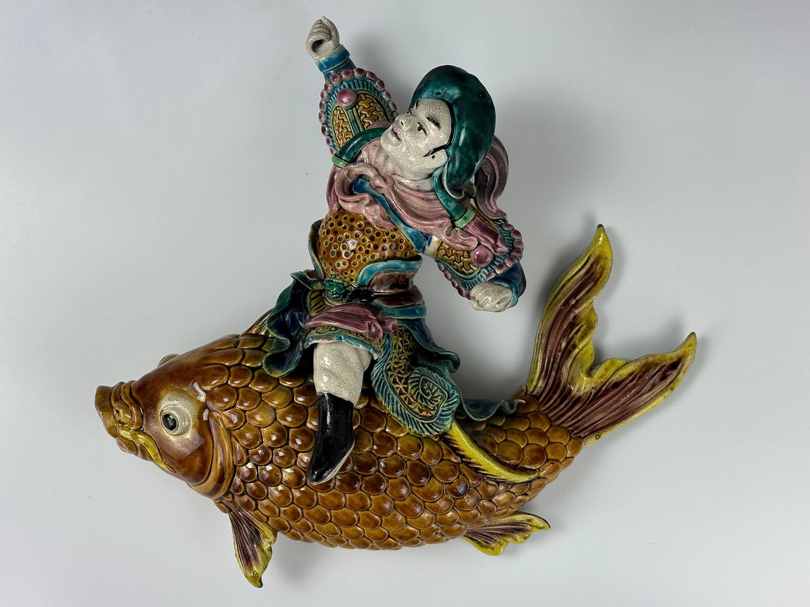 A Chinese Roof Tile of Man Riding Carp: A Chinese Roof Tile of Man Riding Carp,D 32.5 cm(12.6 in.) x H 27.5 cm(10in.),Preview from Aug. 21st to 25th from 1:00 PM TO 5:00 PM Eastern Time, Location: 15229 Display Court, Rockville MD 20850.