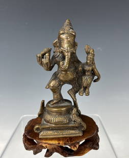 Bronze statue of Ganesh with Wood Base: Bronze statue of Ganesh, the elephant-headed son of Lord Shiva, dancing and holding Lakshmi the goddess of wealth and prosperity. Ganesh is always invoked before any important ceremony or undertaking