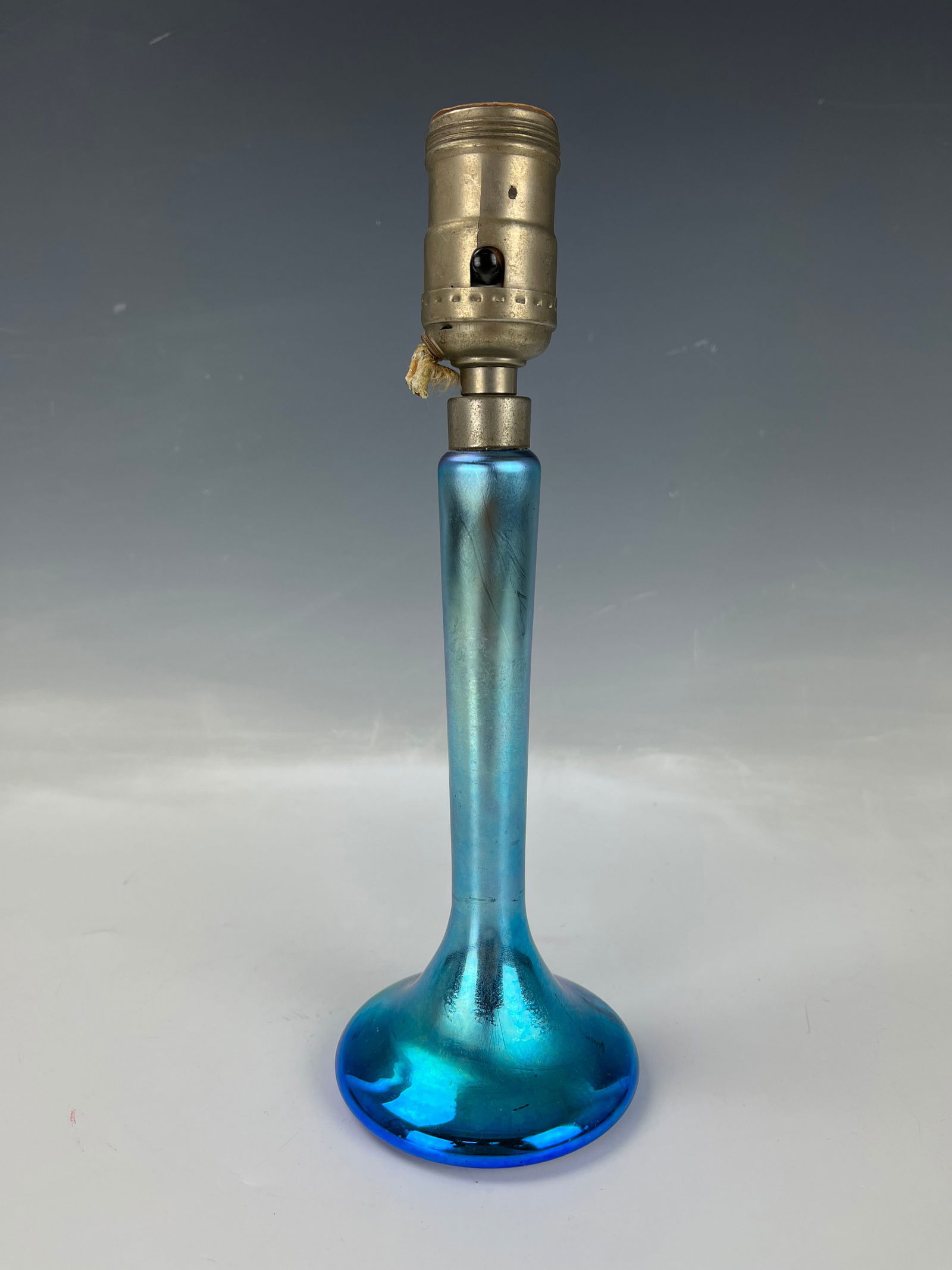Vintage Art Glass Boudoir Lamp: Vintage Art Glass Boudoir Lamp, early 20th century, slender shaft with flaring base in iridescent blue glass.H 26.7 cm( 10.5 in.) Preview from Apr. 22nd to 26th from 1:00 PM TO 5:00 PM Eastern Time, L