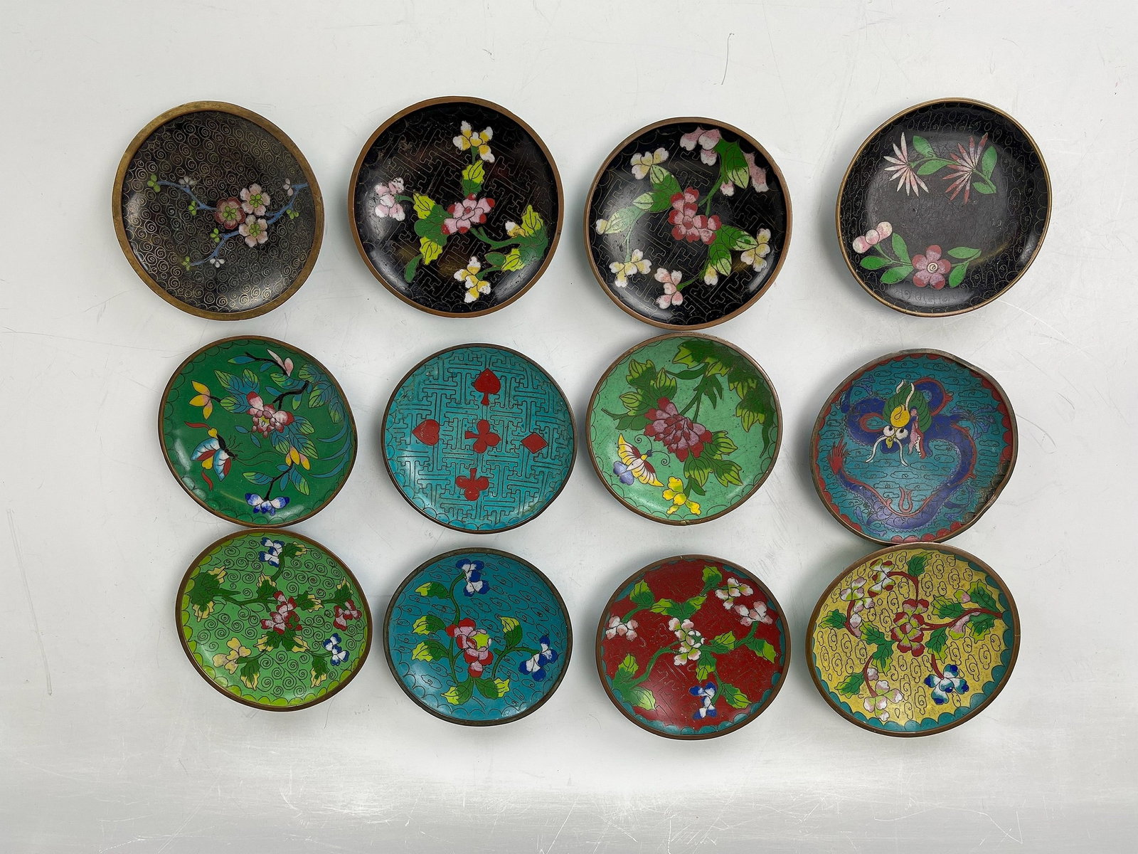 Group of 12 Antique Early 20th Century Cloisonne Coasters: Group of 12 Antique Early 20th Century Cloisonne Coasters, D 8 cm (3.2 in.) x 12, Preview from May 27th to 31st from 1:00 PM TO 5:00 PM Eastern Time, Location: 15229 Display Court, Rockville MD 20850.