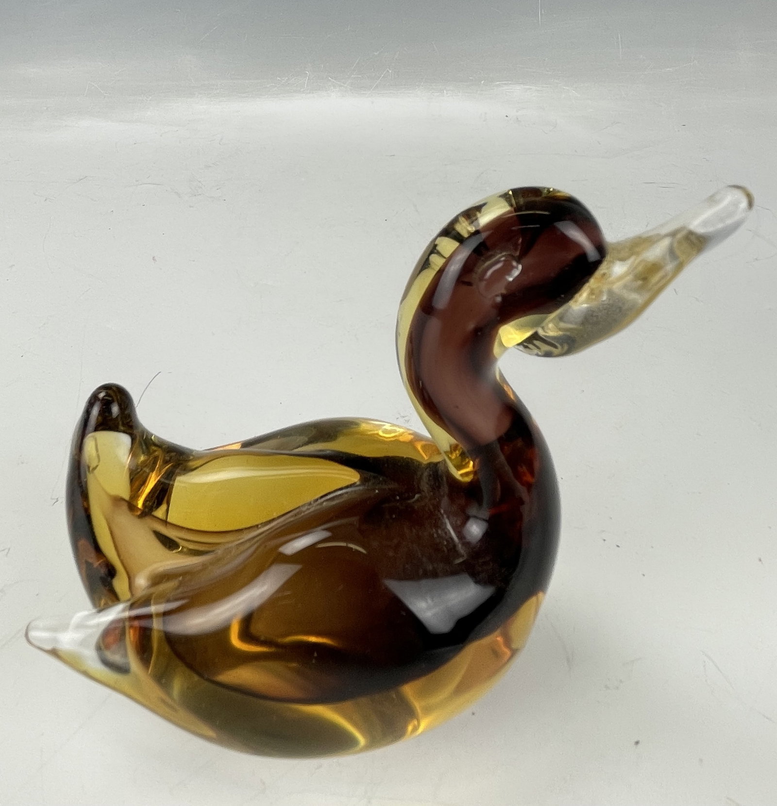 A Vintage Amber Art Glass Duck Figurine: A Vintage Amber Art Glass Duck Figurine, H 10.2 cm (4 in.) x W 10.2 cm (4 in.), Preview from May 27th to 31st from 1:00 PM TO 5:00 PM Eastern Time, Location: 15229 Display Court, Rockville MD 20850.