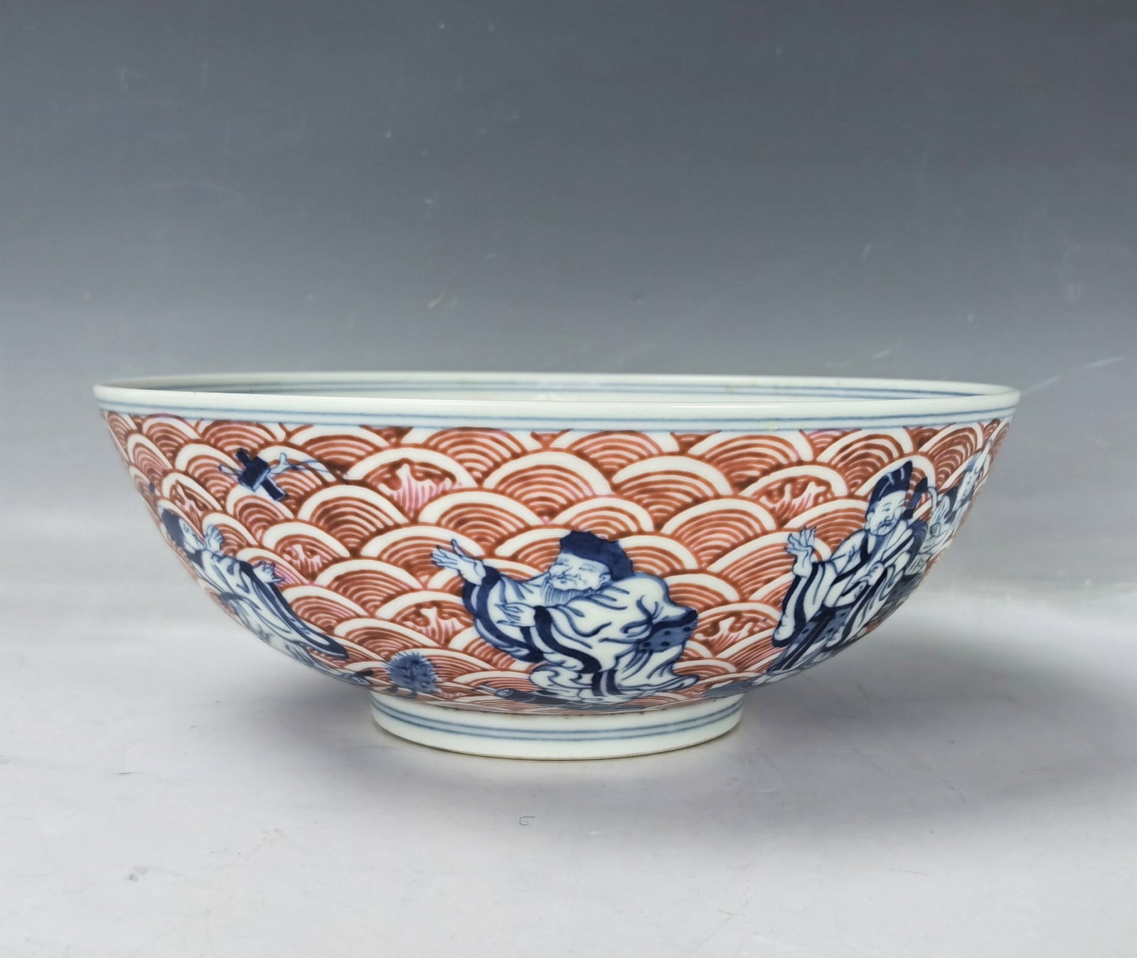 A Large Bowl Painted Eight Immortals Crossing the Sea Qianlong Mark: Large bowl painted in blue & white and copper-red Eight Immortals Crossing the Sea. Qianlong Mark,D 22 cm(8.7 in.) X H 8 cm(5.2 in.). Preview from Aug. 26th to 30th from 1:00 PM TO 5:00 PM Eastern Tim