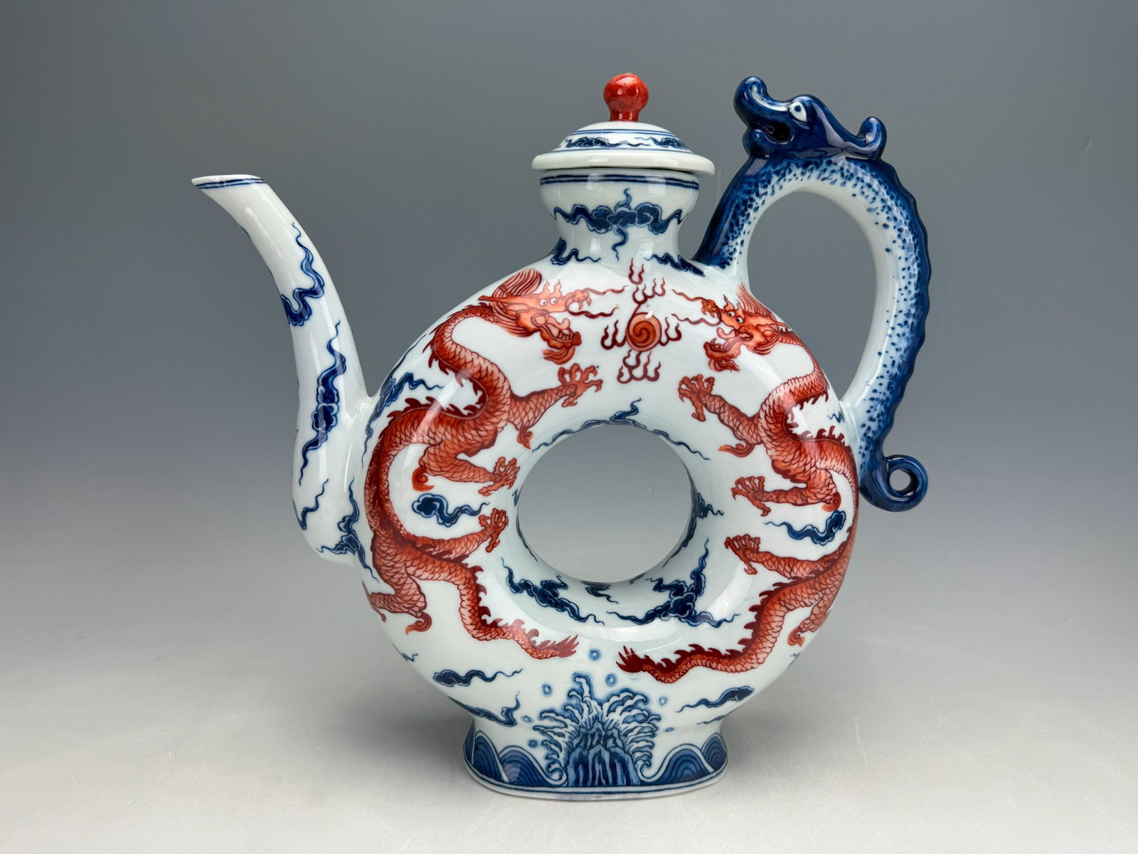 20th century Blue & white and Under Glaze Red Porcelain Wine Pot Marked: 20th century Blue & white and under-glaze red wine pot painted with dragons among flowers.Lid was repaired, Sold as is. H 25cm(10 in.),Preview from Feb.17th to 21st from 1:00 PM TO 5:00 PM Eastern Tim