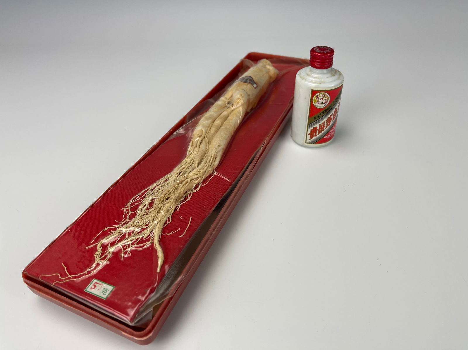 Vintage Chinese Ginseng Root in Box And Kweichow Moutai 50ml Bottle: Vintage Chinese Ginseng Root in Box And Kweichow Moutai 50ml Bottle, This Moutai has leaked over time due to age, and only half the liquor remains,sold as is.Preview from Feb 23rd to 27th from 1:00 PM