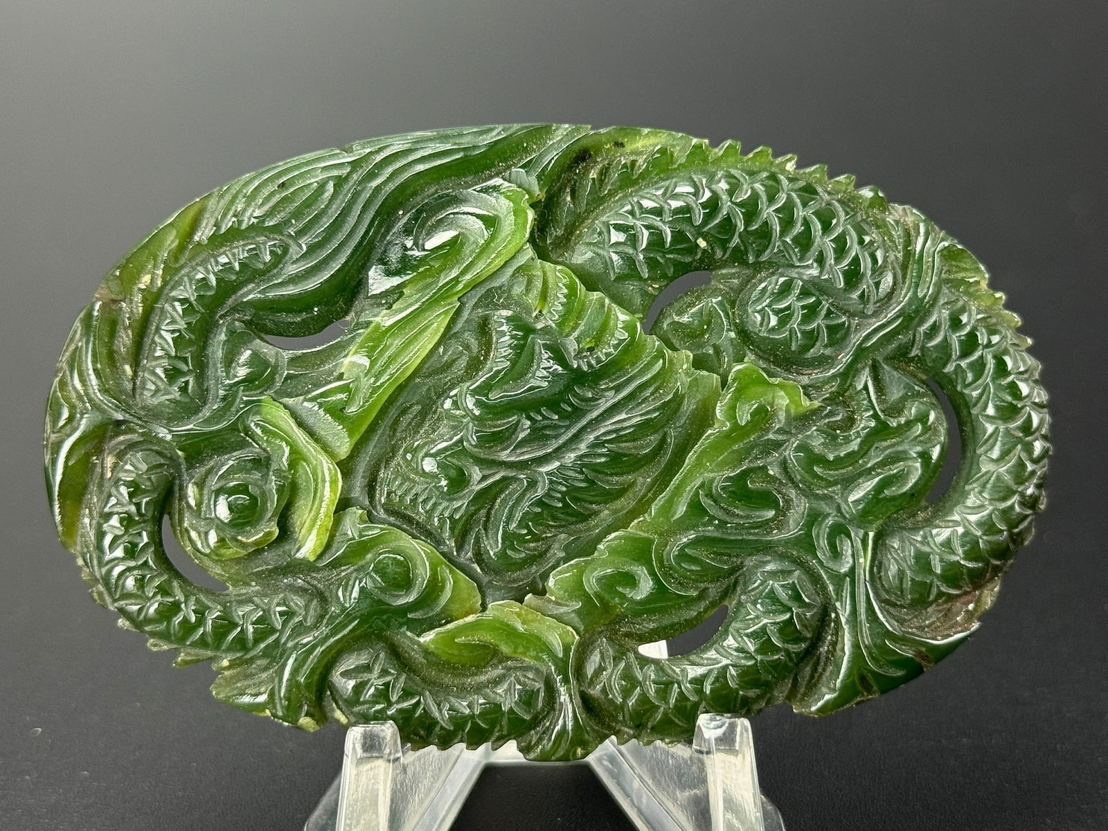 A Chinese Green Jade Pendant Carved with a Dragon: A Chinese jade pendant carved with a dragon motif, featuring a movable dragon head.size 7.5 x 4.5 cm.Preview from Apr 20th to 24th from 1:00 PM TO 5:00 PM Eastern Time, Location: 15229 Display Court,