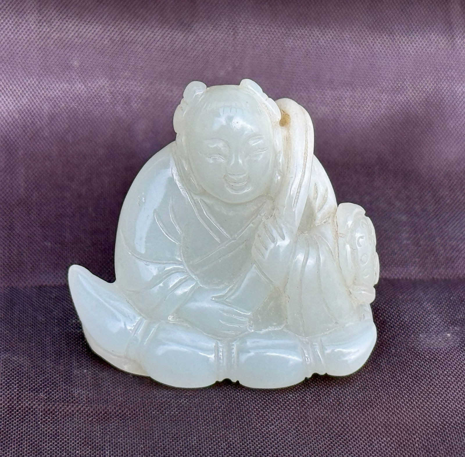 White Jade Carved Toggle of Boy with Lotus: White Jade carved toggle of a boy with lotus. H 4cm(1.7 in.) x W 4 cm(1.5 in.).Preview from Apr 20th to 24th from 1:00 PM TO 5:00 PM Eastern Time, Location: 15229 Display Court, Rockville, MD 20850.