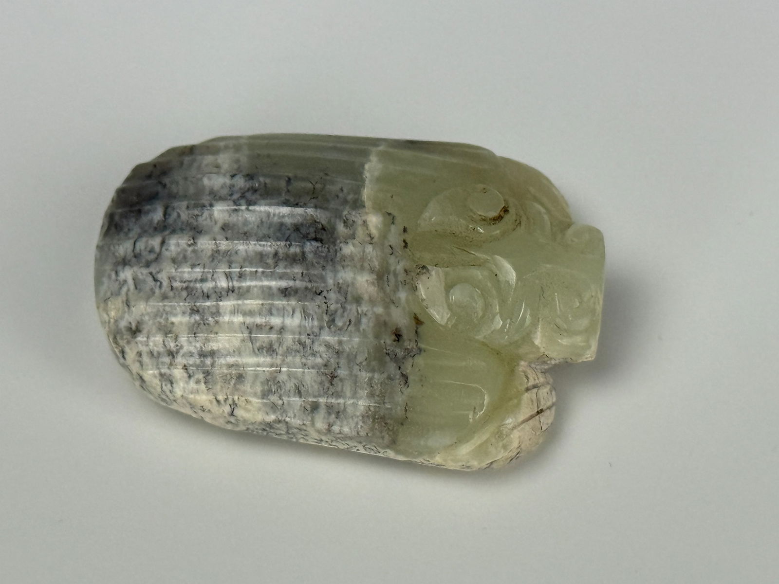 A Small Celadon Jade Carved Paper Weight: Celadon Jade carved scroll weight with dragon patterns, size 3 x 4cm.Preview from Apr 20th to 24th from 1:00 PM TO 5:00 PM Eastern Time, Location: 15229 Display Court, Rockville, MD 20850.