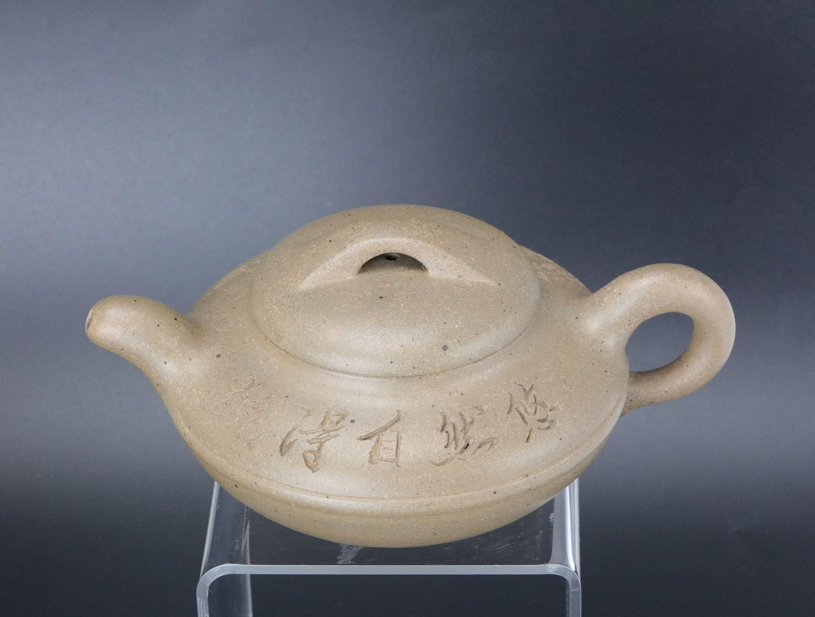 A Chinese Yixing White Sand Clay Teapot Marked: Yixing white sand teapot with maker's name in seal script, W 18.4 cm ( 7.5in.) x H 6 cm (2.6 in.).Preview from Apr 20th to 24th from 1:00 PM TO 5:00 PM Eastern Time, Location: 15229 Display Court, Roc