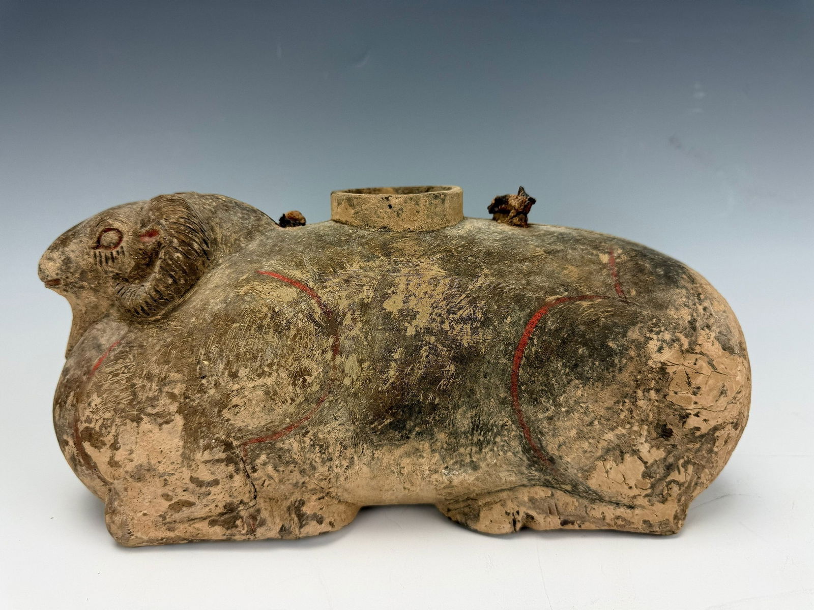 Chinese Han Dynasty Pottery Zoomorphic Ram Vessel: A Chinese Pottery zoomorphic vessel, Han dynasty, modelled as a recumbent ram,with traces of red pigment.size W 31 cm (12 in) x H 16 cm (6 in) x D 12 cm (5 in). Provenance from Dr. Constantine collect