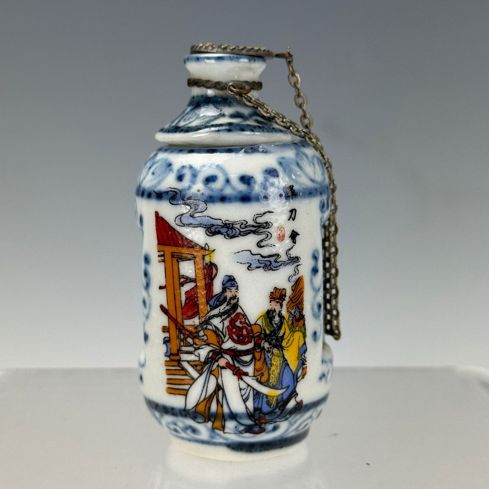 A 20thC Chinese Porcelain Erotic Snuff Bottle: A 20thC Chinese porcelain erotic snuff bottle, of cylindrical form, with a revolving top and inner section decorated with a copulating couple, the exterior with figural scenes, four character mark but