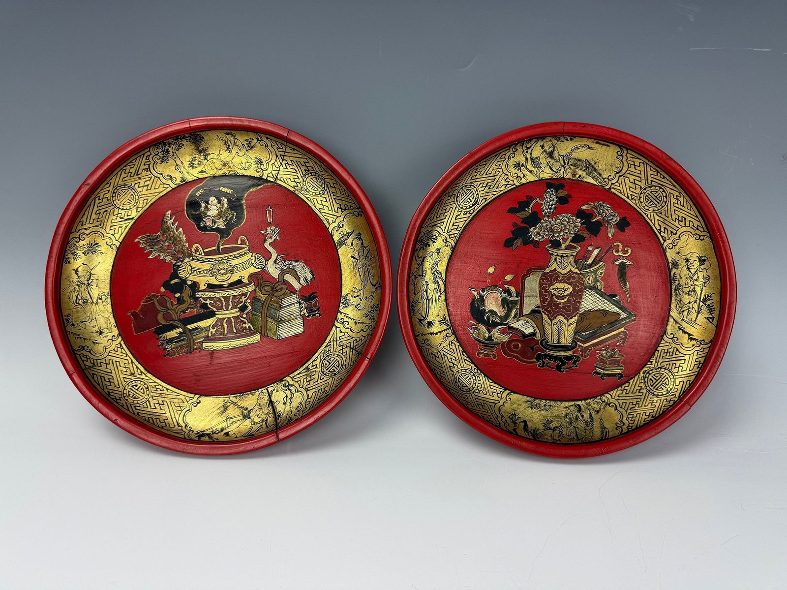 Pair of Chinese Antique Red lacquer Plates With Gilt Eight Immortals: Pair of red lacquered gold-painted wooden plates with immortals and traditional vessels and scholar objects, various auspicious patterns on them; they are usually used for marriage, one of the dowries
