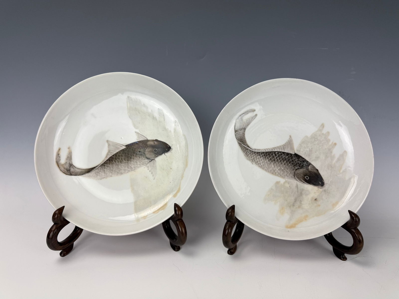 Pair of Chinese Rouge Enamel and Mocai Fish Porcelain Plates: The Plate is covered to the exterior with a rouge enamel, the interior is mocai fish, with an original box and two wood stands. D 19.5 cm(7.8 in.) x 2.Preview from Apr 20th to 24th from 1:00 PM TO 5:0