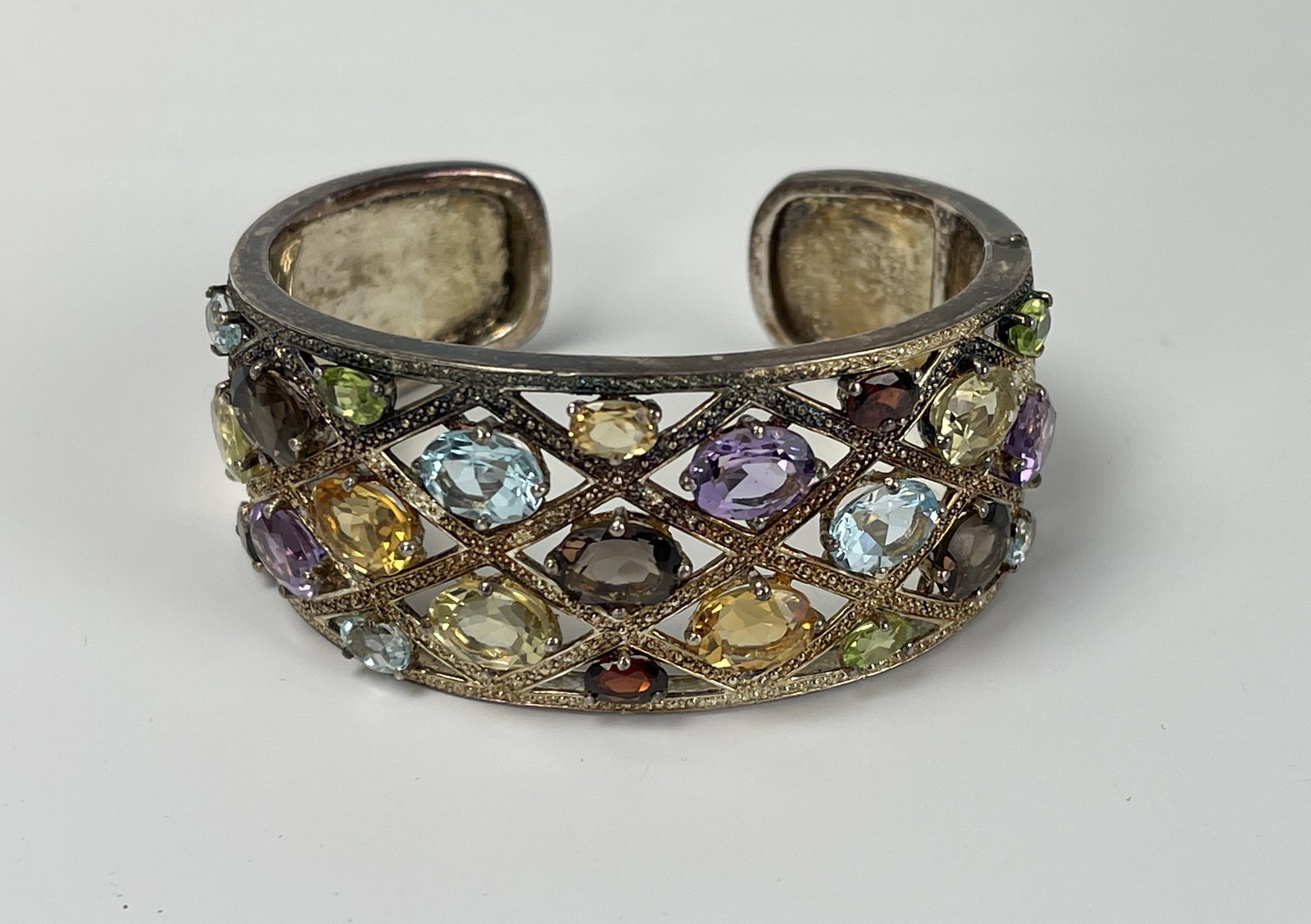 A Multi Stone Hinged Cuff Bracelet: A Multi Stone Hinged Cuff Bracelet, Materials: Silver, Stainless steel, Stone.D 6 cm(2.5 in.).Preview from Apr 20th to 24th from 1:00 PM TO 5:00 PM Eastern Time, Location: 15229 Display Court, Rockvil