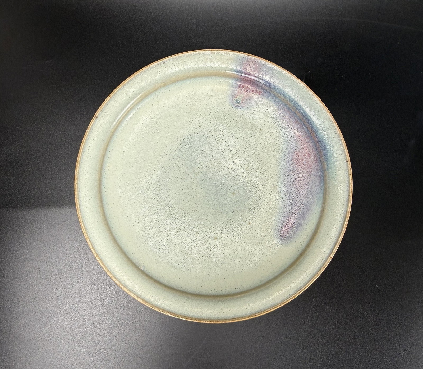 Chinese Light Gray Blue Glazed Ceramic Plate: Light gray?blue glazed ceramic plate with subtle purple?blue rim accents and an unglazed foot ring. D 19cm(7.5in.) x H 3.5cm(1.4in.). Preview from June 22nd to 26th from 1:00 PM TO 5:00 PM Eastern Tim