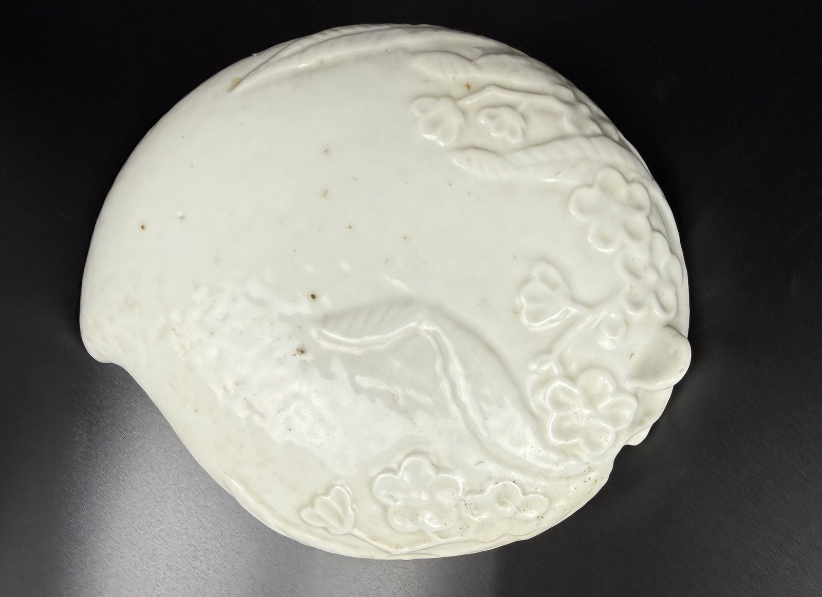 A Peach-shaped Blanc De Chine Covered Porcelain Inkstone: Blanc-de-Chine Covered Inkstone, China, Qing Dynasty, the lid and base molded as an peach-shaped box, decorated with a floral and foliage pattern overall. W 18 cm (7 in.) x D 15 cm (6 in.)x H 6 cm (2.