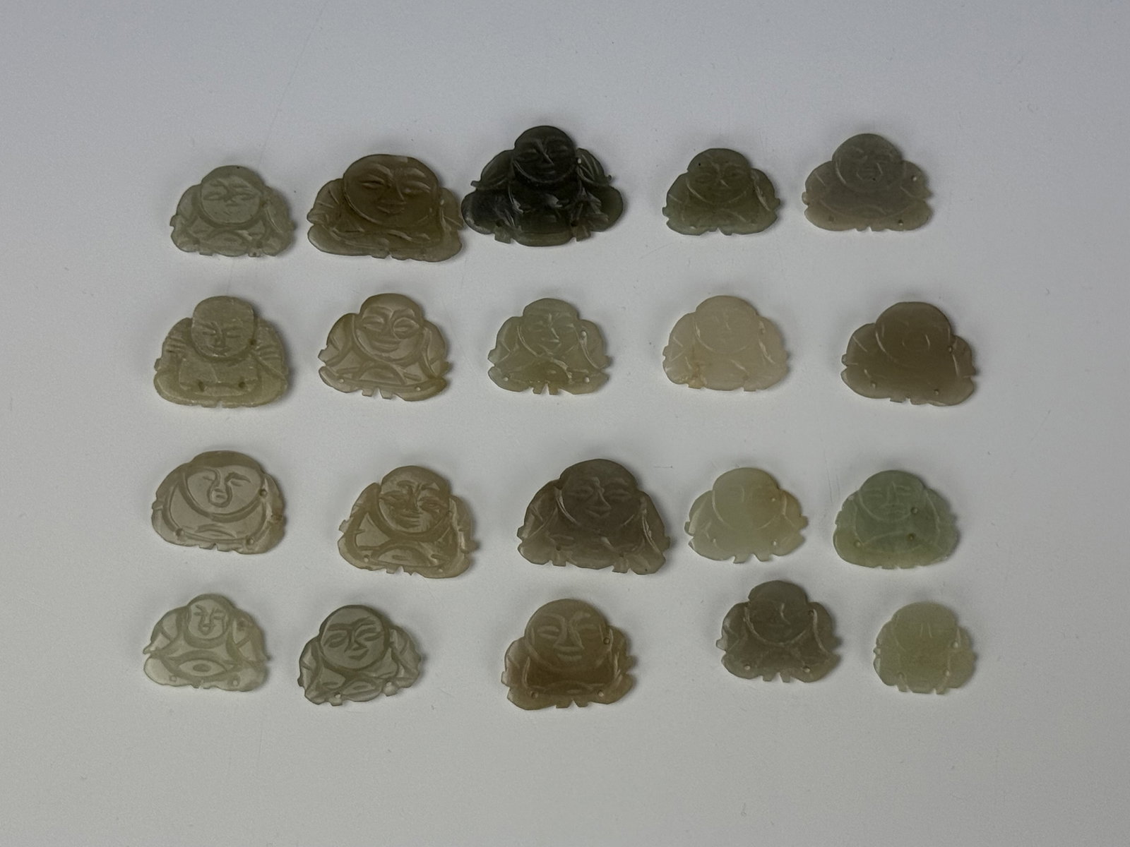 Group of 20 small Chinese Carved Jade Laughing Buddha Pendants: Group of 20 small chinese carved jade laughing buddha pendants. Size 3 x2 cm x 20.Preview from June 22nd to 26th from 1:00 PM TO 5:00 PM Eastern Time, Location: 15229 Display Court, Rockville, MD