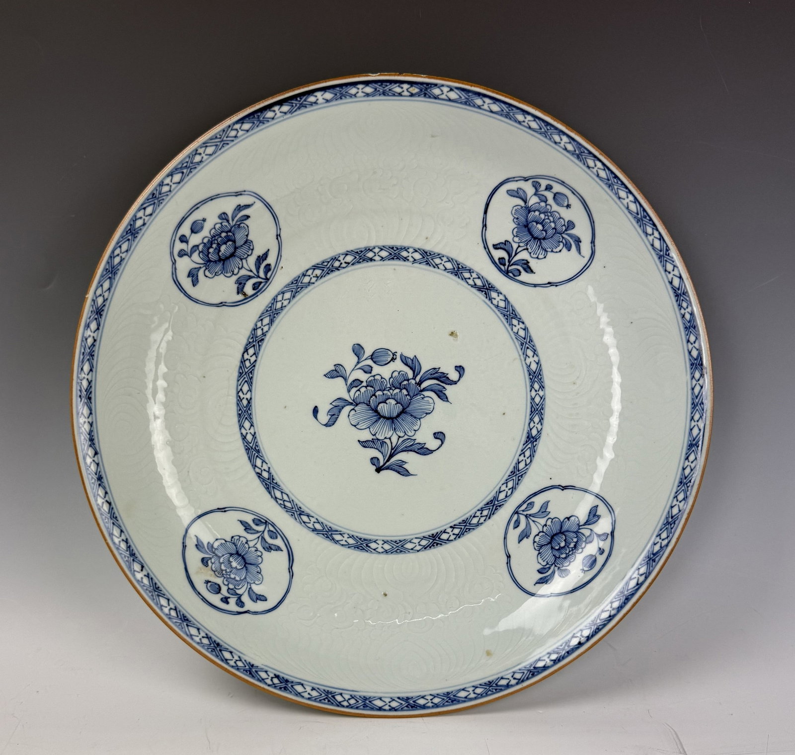Chinese Blue and White Charger with Incised Patterns of Dragons: Blue and white charger painted with flowers of four seasons with incised patterns of dragons. D 35.6cm(14in.) x H 5cm(2in.). Preview from June 22nd to 26th from 1:00 PM to 5:00 PM Eastern Time, Locati
