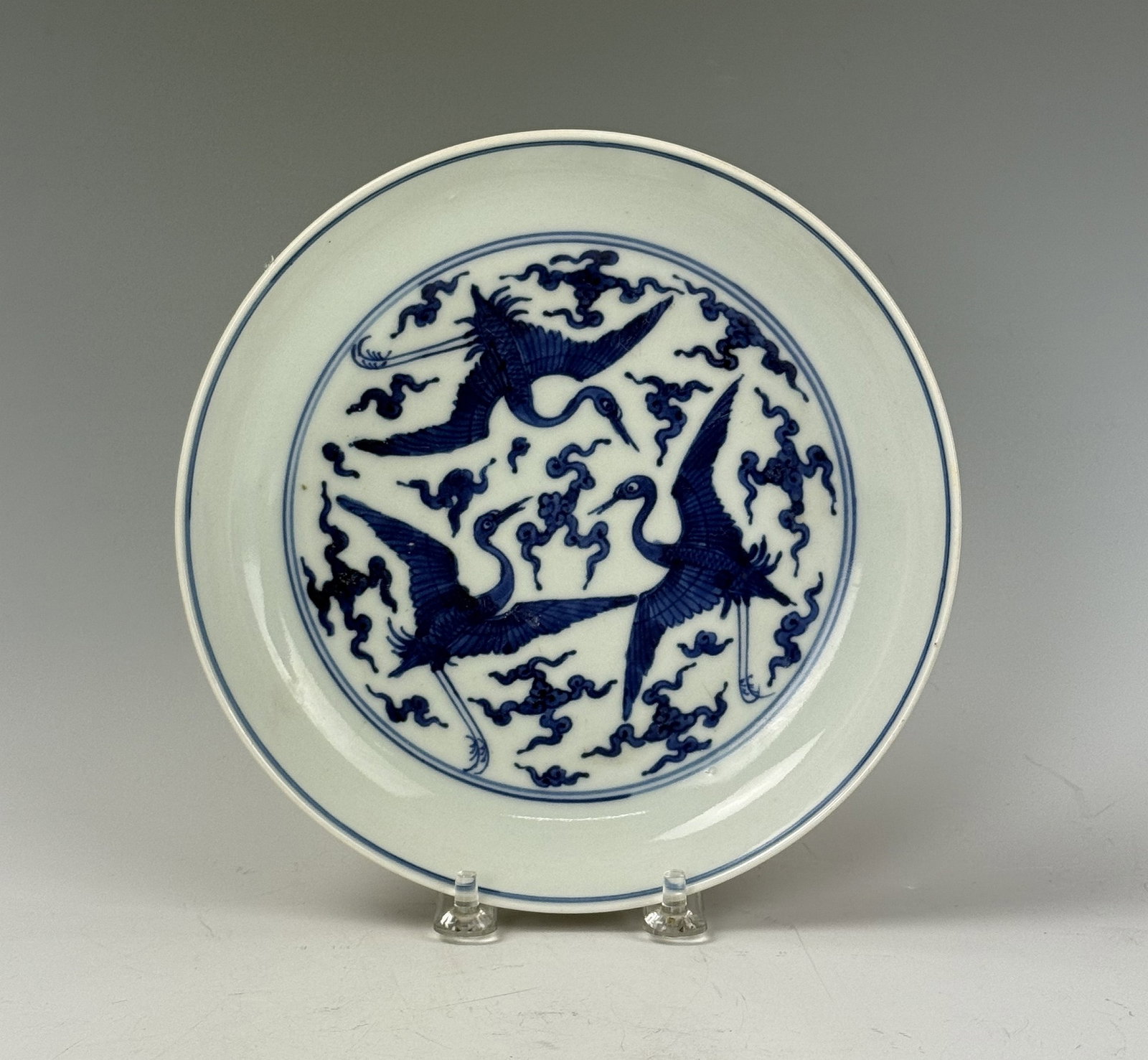 A Blue and White Interior Porcelain Plate with Oxblood Glaze Exterior Jiajing Mark: An imperial style plate with oxblood (sang de beouf) glaze on the exterior and blue and white patterns of clouds and crames on the interior, Jiajing mark. D 19 cm(7.4 in.). Preview from June 22nd to 2