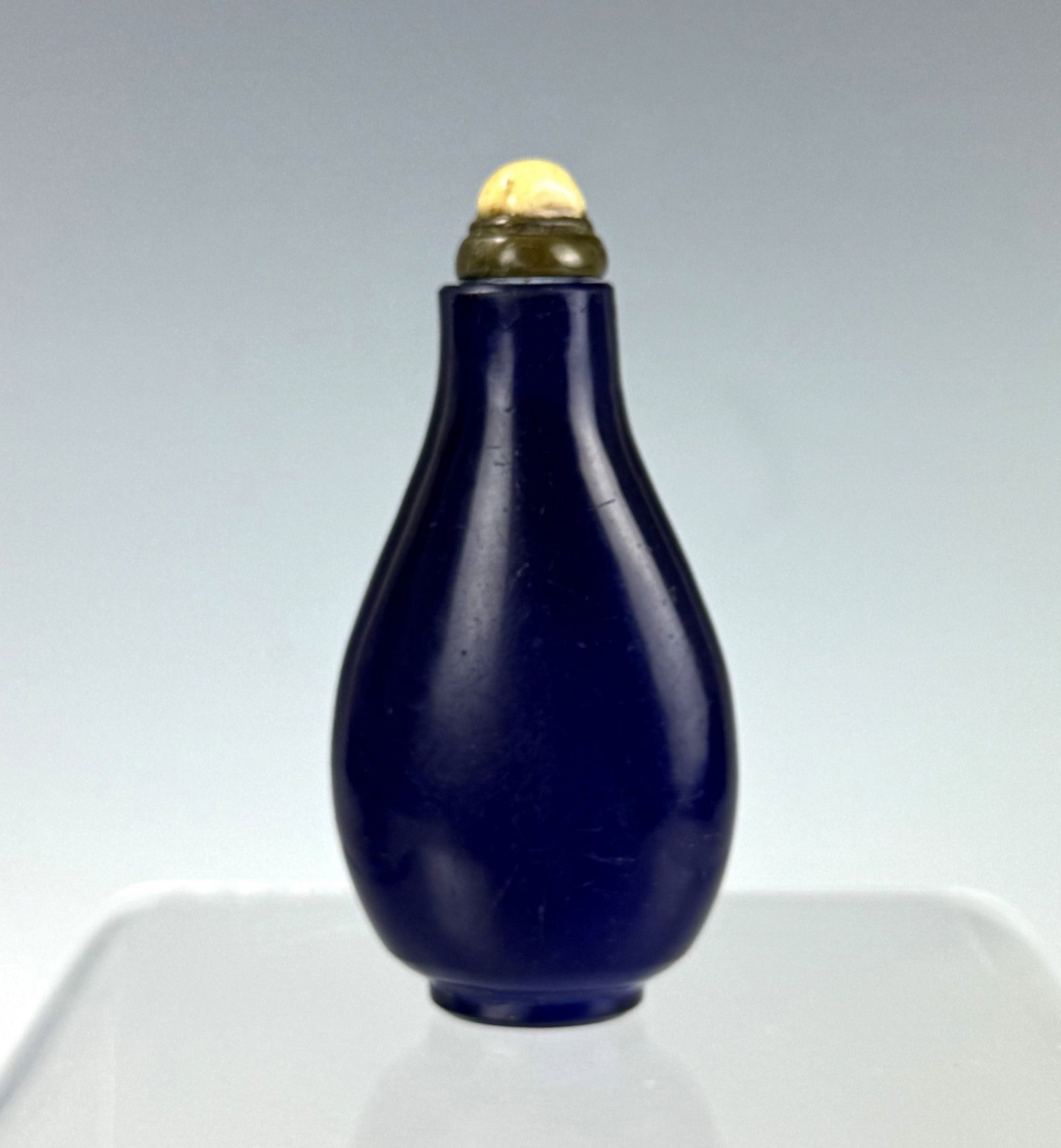 A Chinese Blue Peking Glass Snuff Bottle: Blue glass snuff bottle. H 7.4 cm(2.9in.). Preview from June 22nd to 26th from 1:00 PM TO 5:00 PM Eastern Time, Location: 15229 Display Court, Rockville, MD 20850.