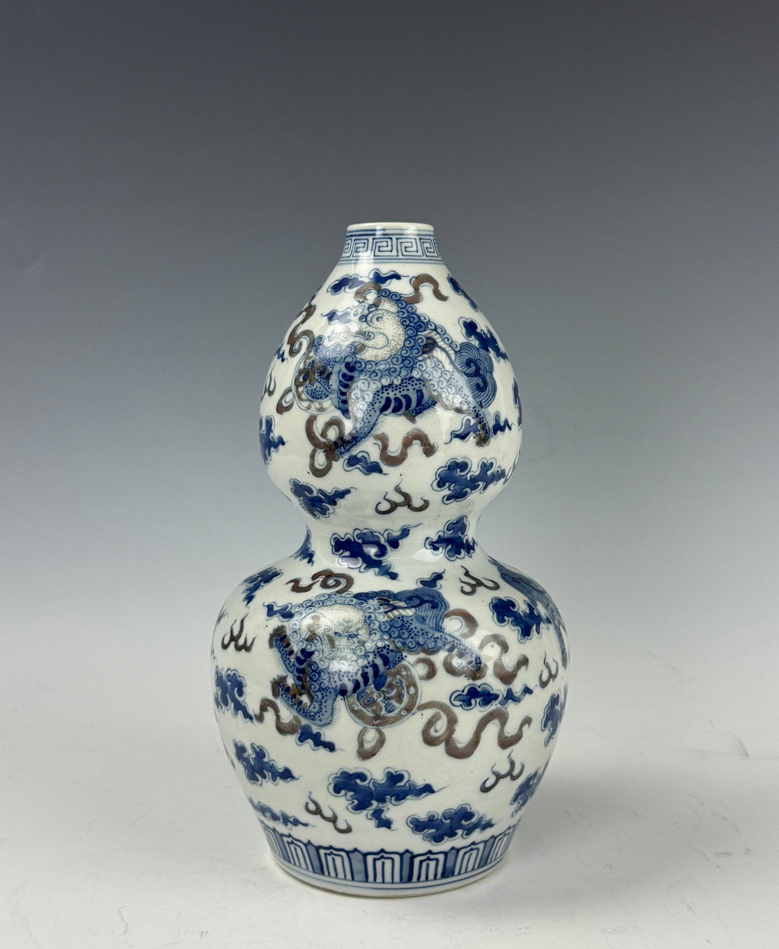 Chinese Under Glaze Red and Blue Gourd Shaped Porcelain Vase: Blue and white gourd shaped vase with copper-red glazed dancing lions. Blue double ring mark. H 24 cm(9.4 in.) x D 13cm(5 in.). Preview from June 22nd to 26th from 1:00 PM TO 5:00 PM Eastern Time, Loc