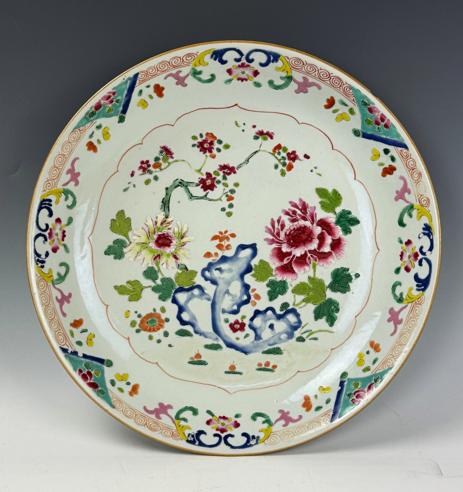 A Large Qing Dynasty Kangxi Famille Rose Charger: Famille rose charger painted with flowers Kangxi Period. D 34cm(13.5 in.) x H 5.5cm(2.2 in.). Preview from June 22nd to 26th from 1:00 PM TO 5:00 PM Eastern Time, Location: 15229 Display Court, Rockvi