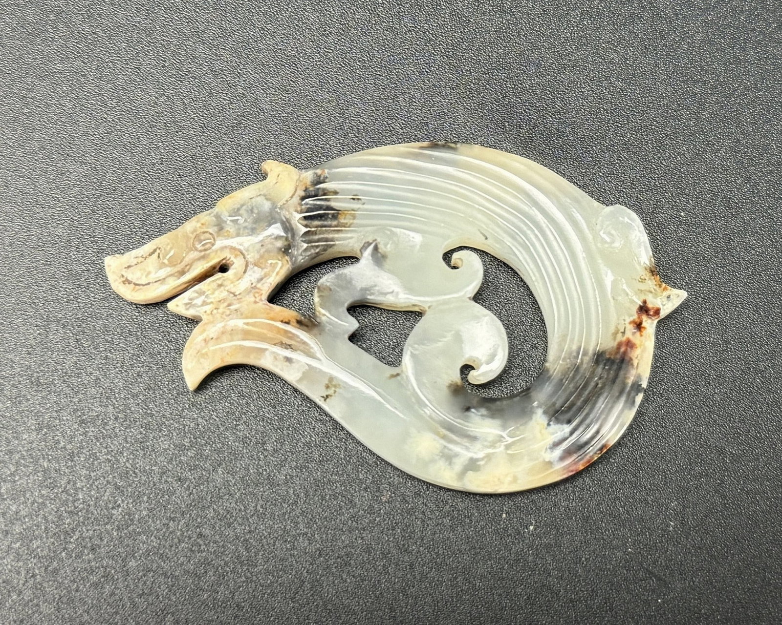 A Chinese Carved Dragon Jade Pendant: A Chinese Carved Dragon Jade Pendant. L 5.4cm(2.1in.) x W 3cm(1.2in.). Preview from June 22nd to 26th from 1:00 PM TO 5:00 PM Eastern Time, Location: 15229 Display Court, Rockville, MD 20850.