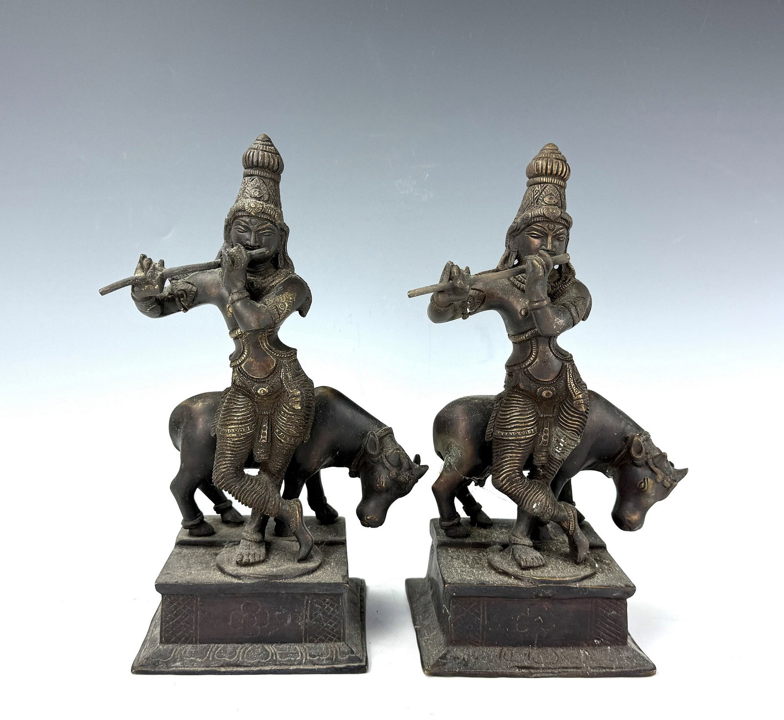 Two Indian Bronze Figurines Krishna Playing Flute: Two Indian Bronze Figurines Krishna Playing Flute H28 cm(11in.) x W 12.5 cm (4.9 in) x D 11.6 cm(4.5in.) x 2. Preview from June 22nd to 26th from 1:00 PM TO 5:00 PM Eastern Time, Location: 15229